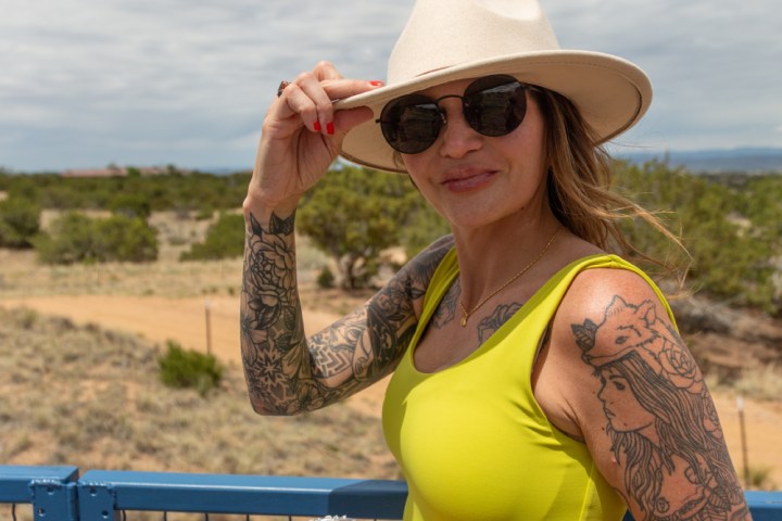 a woman standing next to a fence