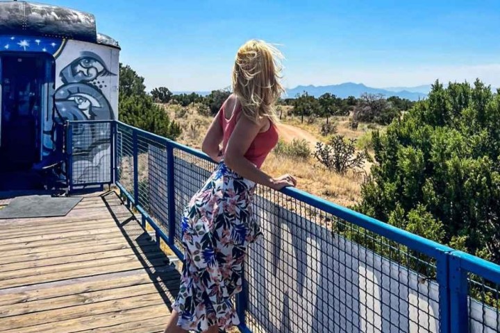 a person standing next to a fence