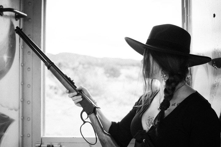 a person wearing a hat and holding a gun